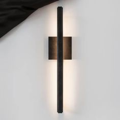 a modern wall light with two lights on it's side and black fabric hanging from the ceiling