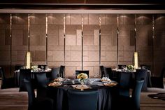 a table set up for an event with black linens and gold place settings