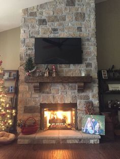 a living room with a fire place and christmas decorations on the fireplace mantels