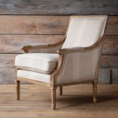 an old chair sitting on top of a wooden floor in front of a wood wall