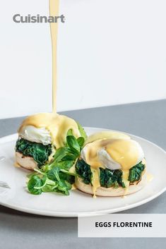 an egg and spinach sandwich being drizzled with mayonnaise on a white plate