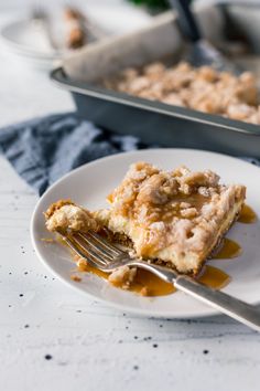 a piece of cake on a white plate with a fork in front of the pie