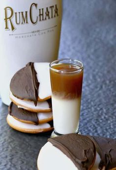 chocolate covered cookies next to a cup of coffee and a bottle of rum chata