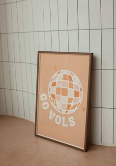 an orange and white poster with the words covols on it in front of a tiled wall