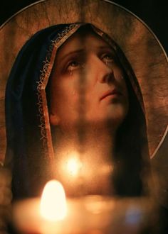 a candle is lit in front of the face of a woman