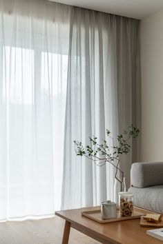 a living room with a couch, coffee table and curtains