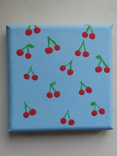 a painting of cherries on a blue background