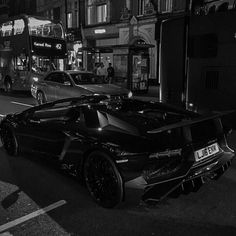 a black and white photo of a car parked in front of a double decker bus