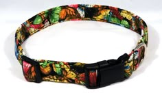 a colorful butterfly print dog collar with black metal buckles and an adjustable closure on the front