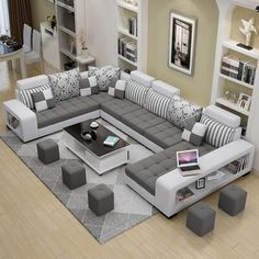 a modern living room with grey and white couches, coffee table and ottomans