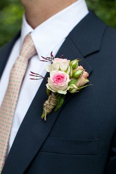 a man in a suit and tie with a boutonniere on his lapel