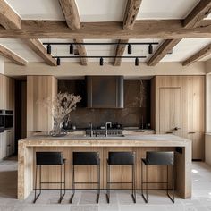 a kitchen with an island and bar stools in the center, surrounded by wood paneling