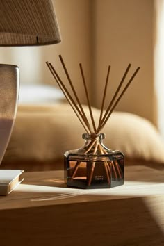 an image of a bedroom setting with reeds on the table next to the bed