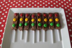 a white plate topped with chocolate covered pretzels on top of a red and white table