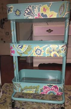 a blue cart sitting on top of a carpeted floor next to a dresser with drawers