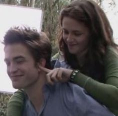 a young man getting his hair cut by a woman