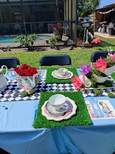 the table is set with flowers and teapots on top of it, along with other decorations