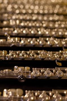 many silver musical instruments are lined up together