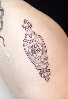 a woman's thigh with a bottle tattoo on it