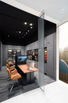 an office with multiple desks and chairs in front of a large display window that displays architectural photographs