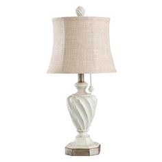 a white table lamp with a beige shade