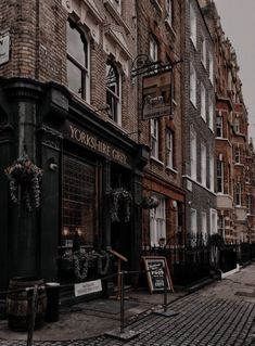 an old brick building on the corner of a cobblestone street