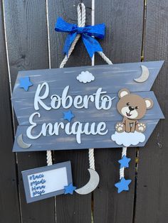 a wooden sign that says roberto enrique with a teddy bear on the front