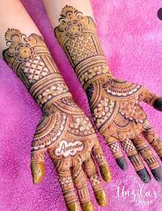 two hands with henna tattoos on them