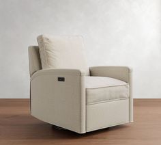 a white recliner chair sitting on top of a wooden floor next to a wall