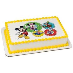 a white and yellow cake with mickey mouse on it's top, surrounded by other cartoon characters