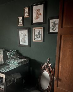 a living room with green walls and pictures on the wall, including a chair in front of a table