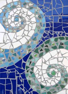 a blue and white mosaic tile wall with two spirals on it's side