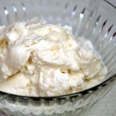 a glass bowl filled with whipped cream on top of a table