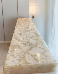 a marble counter top in the corner of a room with white walls and flooring