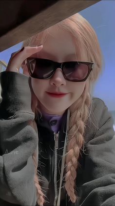 a woman with long hair wearing sunglasses and a jacket