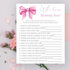 a baby shower game with pink bows and flowers next to it on a white surface