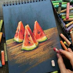 a drawing of watermelon slices with crayons next to it