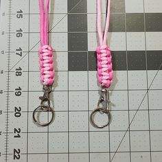 two pink lanyards on a ruler with one being used as a keychain