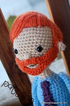 a crocheted doll with a red beard wearing a blue sweater