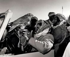 black and white photograph of people in the back of a truck with birds on their heads