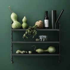 a shelf filled with different types of fruits and veggies next to a bottle of wine