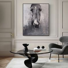 a modern living room with a horse painting on the wall and an oval glass coffee table