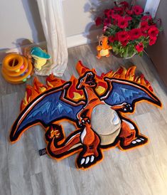 an orange and blue dragon rug sitting on the floor next to a potted plant