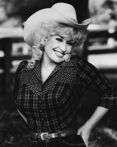 an old black and white photo of a woman wearing a cowboy hat with her hands on her hips