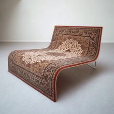 an intricately designed chaise lounge chair in a room with white walls and carpet