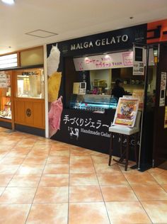 the inside of a restaurant with tile flooring and signs on the walls that read, mausa gelato