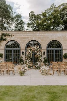 an outdoor ceremony setup with wooden chairs and flowers