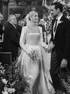 a bride and groom walking down the aisle at their wedding ceremony in black and white