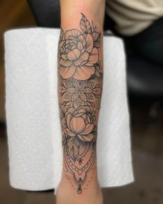 a woman's arm with a flower tattoo on it