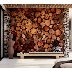 there is a large pile of logs on the wall next to a bench and vase